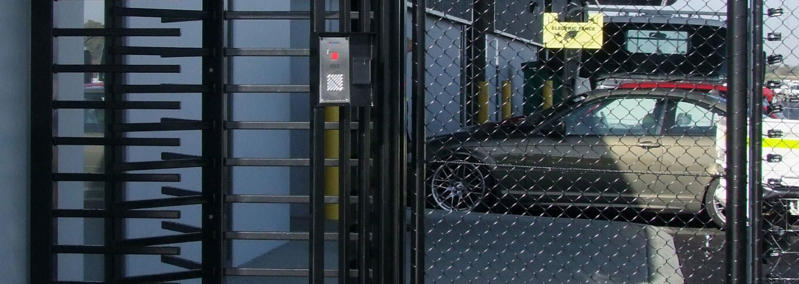 Full-height pedestrian turnstile beside an access intercom